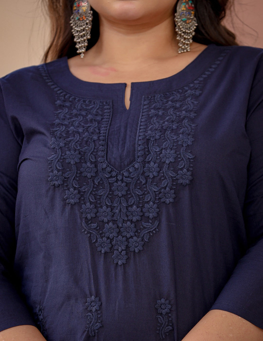 Navy blue top with intricate lace detailing on a plain background